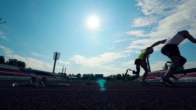 Two disabled sportsmen with prosthetic legs start running