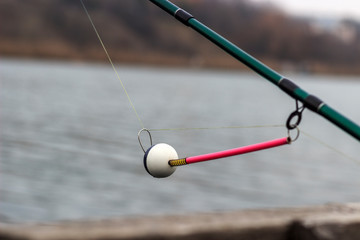 spinning bite indicator, a nod on a fishing rod by the river