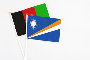 Marshall Islands and Afghanistan stick flags on white background. High quality fabric, miniature...