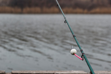 spinning bite indicator, a nod on a fishing rod by the river