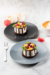 Mini round souffle cake with fruit and chocholate glaze on topc on marble background. Wallpaper for pastry cafe or cafe menu. vertical.