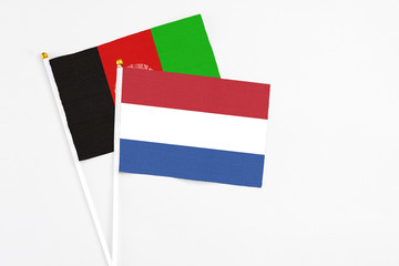 Netherlands and Afghanistan stick flags on white background. High quality fabric, miniature...