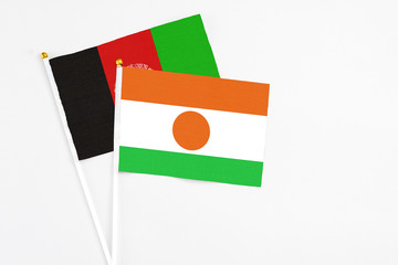 Niger and Afghanistan stick flags on white background. High quality fabric, miniature national...