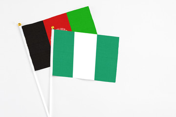 Nigeria and Afghanistan stick flags on white background. High quality fabric, miniature national...