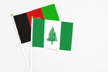 Norfolk Island and Afghanistan stick flags on white background. High quality fabric, miniature...