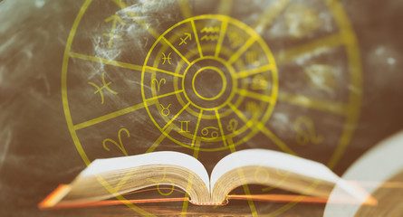Zodiac signs set over an open book, abstract background.