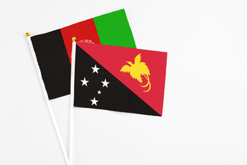Papua New Guinea and Afghanistan stick flags on white background. High quality fabric, miniature national flag. Peaceful global concept.White floor for copy space.