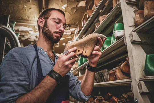Bearded cobbler in glasses found the right shoe form for his new collection.