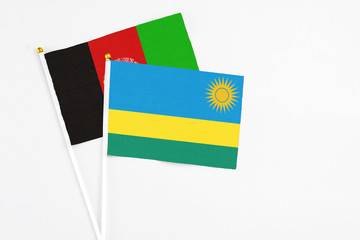 Rwanda and Afghanistan stick flags on white background. High quality fabric, miniature national...