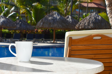 Cup of coffee table and swimming pool in hotel