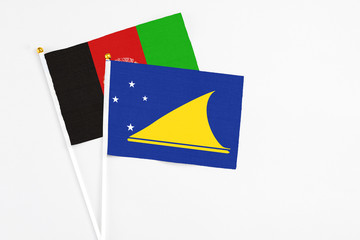 Tokelau and Afghanistan stick flags on white background. High quality fabric, miniature national...