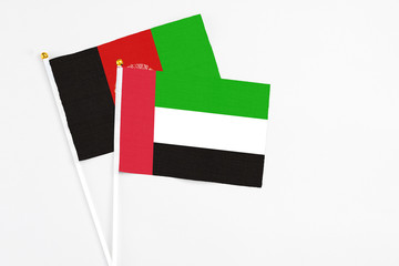 United Arab Emirates and Afghanistan stick flags on white background. High quality fabric, miniature national flag. Peaceful global concept.White floor for copy space.