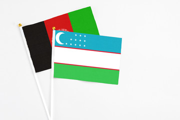 Uzbekistan and Afghanistan stick flags on white background. High quality fabric, miniature national...
