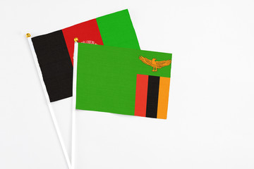 Zambia and Afghanistan stick flags on white background. High quality fabric, miniature national...