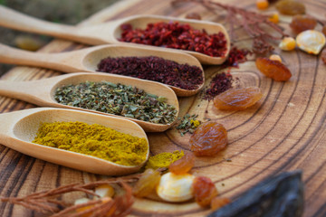 wooden spoons, different kinds of spices, pepper, turmeric, thyme and sumac on wooden background.Isolated background with copy space