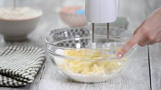 Mixing butter and sugar in bowl with mixing machine, making bakery.
