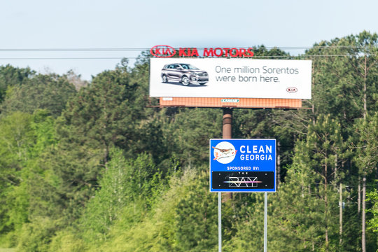 West Point, USA - April 21, 2018: Highway, road signs of Clean Georgia state sponsored by the Ray and Kia Motors billboard, one million Sorentos were born here