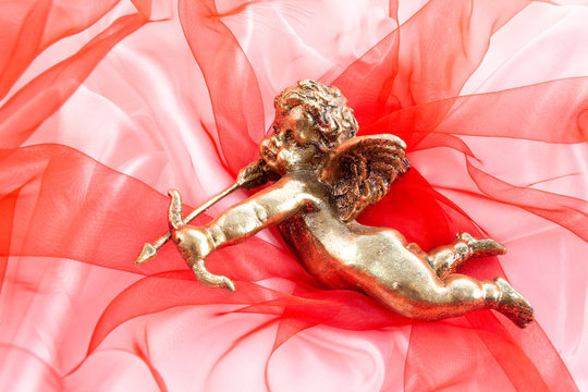 big gold kupidon on  red background