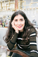 Attractive 35 years old mid adult woman looking at camera in bar