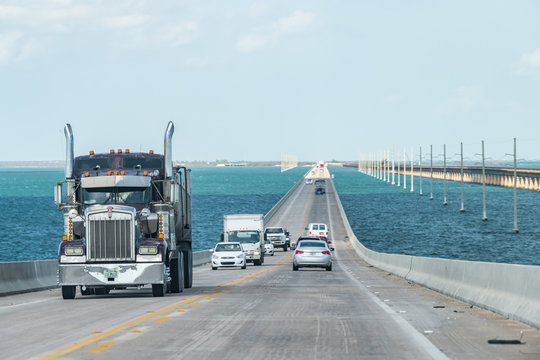 Piegon Key, USA - May 1, 2018: Point of view driving, moving in car on seven mile bridge landscape of Florida Keys water, atlantic ocean, many cars, trucks on Overseas Highway US1 road, route