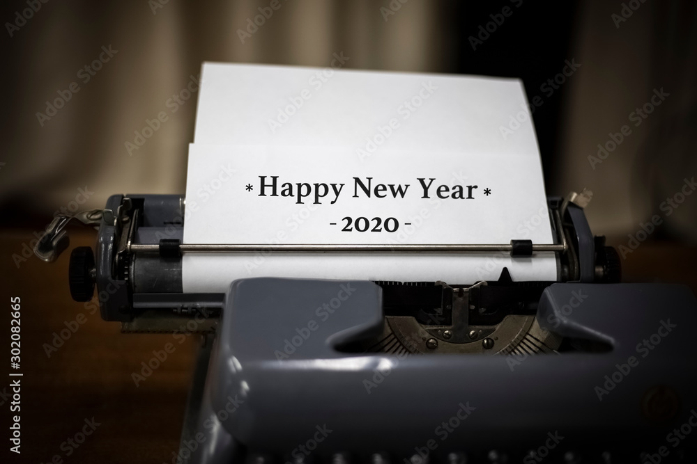 Fototapete old typewriter with white paper sheet and text happy new year 2020. holiday concept. space for your 