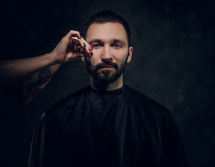 Concept of barbershop - elegant man gets a hair trimming from female hairdresser.