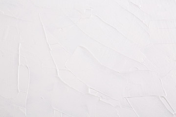 Abstract background texture of strokes of white art paint on canvas.
