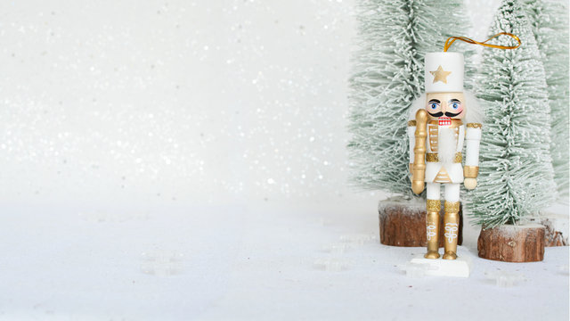 Christmas nutcracker toy soldier figurine ornament in white. Decoration for new year.  Nutcracker on the white sparkling background. Advent concept.