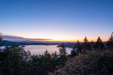 smooth sunset over trees and water below