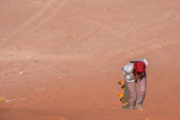 A woman riding a sandboarding