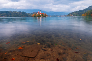Famous Bled Lake in Triglav National Park in the Julian Alps with a forest in autumn colors at...