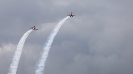 Acrobatic Biplane Flight with People on the Wings during Airshow