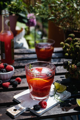 Cold refreshing lime, blackberry and raspberry lemonade with ice on wooden rustic table