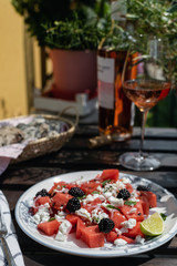 Beautiful healthy lunch, feta cheese, watermelon, blackberry, mint salad with rose wine