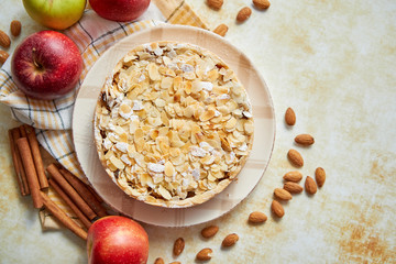 Freshly baked homemade apple pie with almond flakes cake on yellow