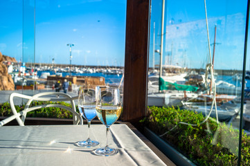 Obraz premium glasses of wine on a table in a restaurant with sea view