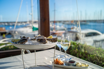 dish with oysters on a table in a restaurant with sea view