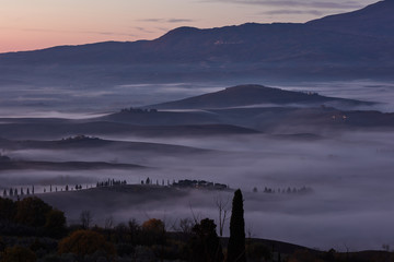 Tuscan landscape at sunrise under the fog