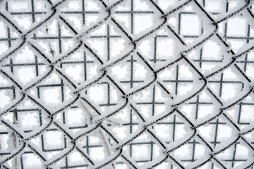 snow-covered ice-covered mesh fence