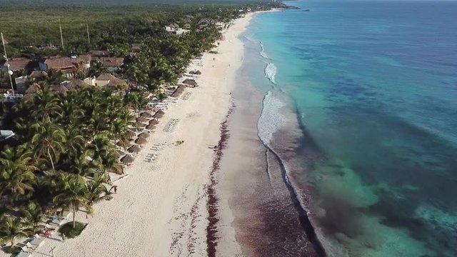 Top view of beautiful beach. Aerial drone shot of turquoise sea water at the beach. Luxury tropical resort with white sand. Aerial view