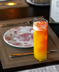 fresh orange and peach alcohol cocktail at a restaurant interior 