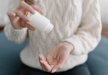 Last antibiotic tablet - a woman pours the last medicine from the package into the palm of her hand. Treatment with expensive drugs. The concept of medicine and pharmacy