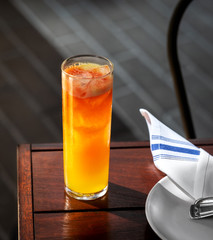 fresh orange and peach alcohol cocktail outside at a restaurant interior 