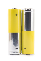 alkaline batteries and a yellow metal AA-size batteries isolated on white background closeup,...