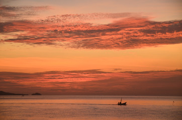 A picturesque tropical  burnt orange coloured altocumulus cloudy coastal sunrise seascape. Thailand.