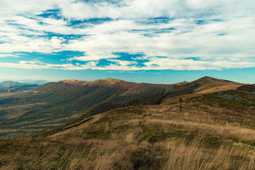 panorama of gorgeous dramatic mountain ridge scenic view landscape photography in moody colors and cloudy blue sky background 