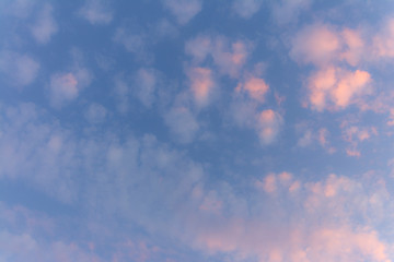 the sun shining through the clouds against the blue sky, light clouds in the sky, traces of aircraft