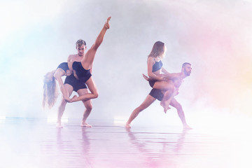 Young modern dancers dancing in the studio. Sport, dancing and urban culture concept. Group of young dancers performing on the stage. Effective performance. beautiful dance.