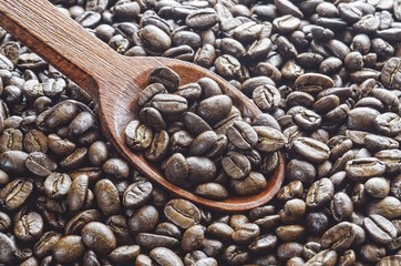 Dark black Coffee. Fresh coffee beans with a wooden spoon.