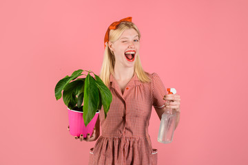 Watering concept. Woman with spray bottle spraying houseplants. Housewife spraying plant with...